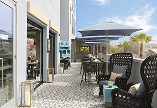 Patio with 4 tables leading to open air dining room